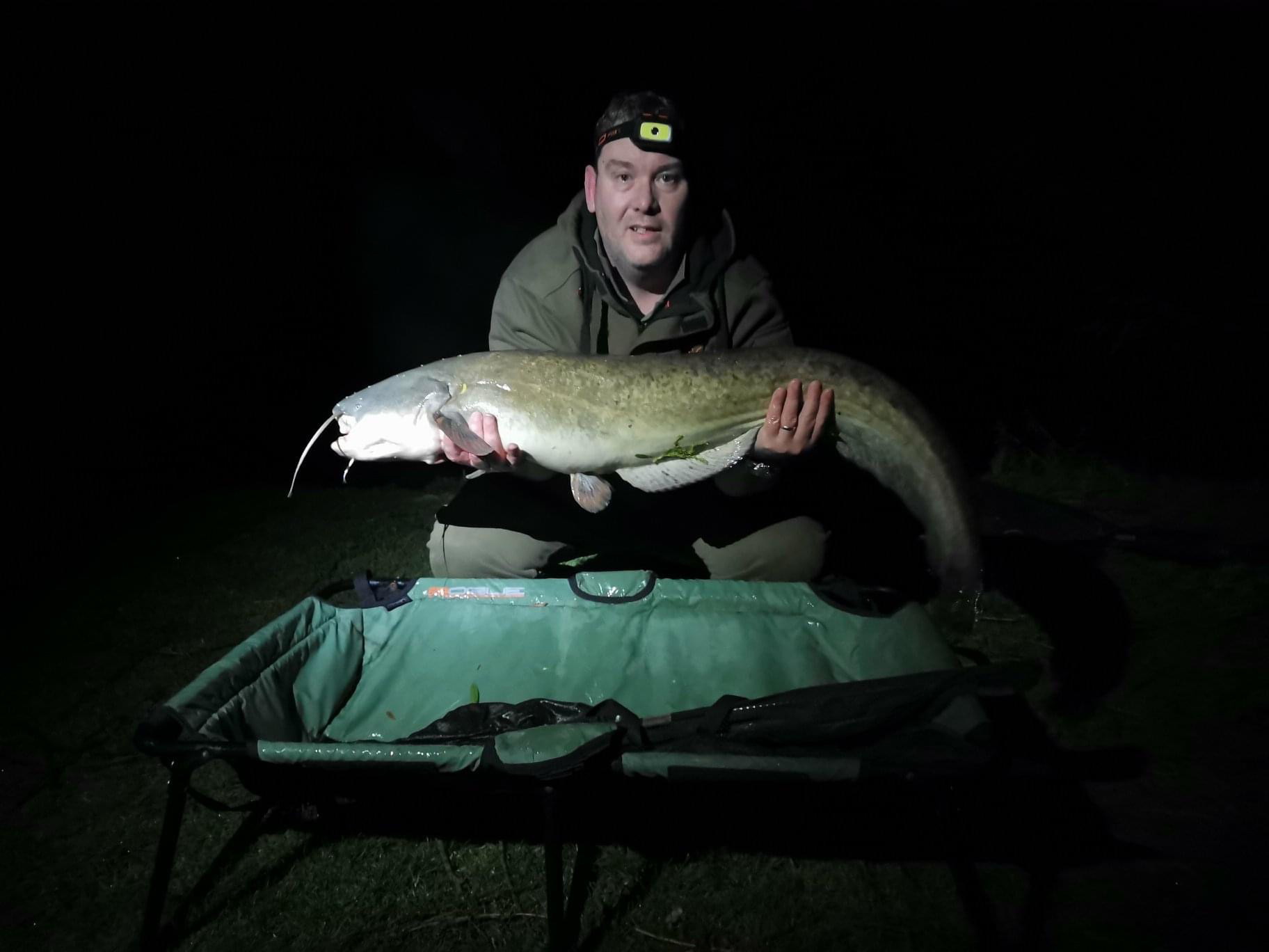 Coole Acres Fishery photo of angler at night with fish